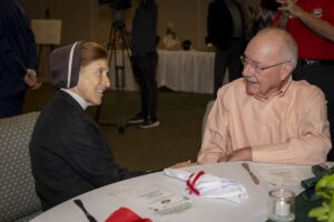 A man and woman sitting at a table talking.