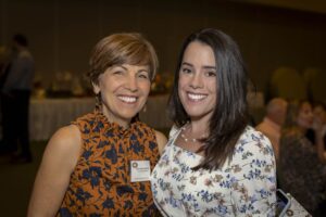 Two women smiling for a picture at an event.