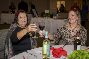 Two women sitting at a table with wine glasses.