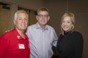 Three people posing for a picture at an event.