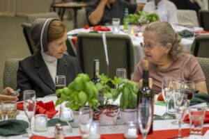 Two women sitting at a table with wine glasses.
