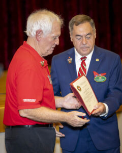 Two men standing next to each other holding a plaque.