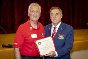A man and woman holding a red document.