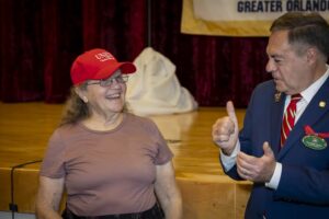 A woman wearing a red hat and smiling at another man.