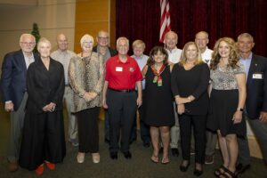 A group of people standing in front of an american flag.