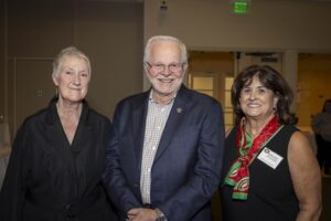 Three people standing next to each other in a room.