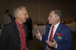Two men talking to each other at a party.