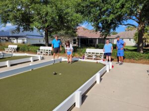 A group of people playing bocce ball on the court.