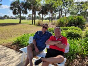 Two men sitting on a bench in the park.