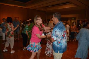 A woman and man dancing in front of other people.