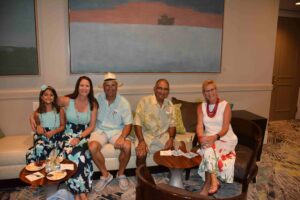 A group of people sitting on top of a white couch.