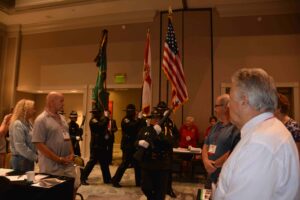 A group of people standing around in front of flags.
