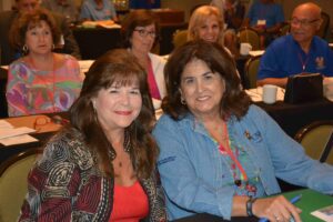 Two women sitting next to each other in a room.