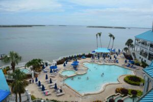 A pool with many chairs and umbrellas in the shape of a heart.