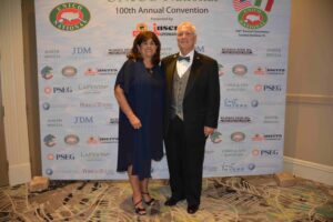 A man and woman posing for a picture in front of a wall.