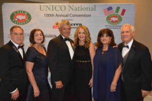 A group of people standing in front of a sign.