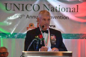 A man in military uniform speaking at an event.